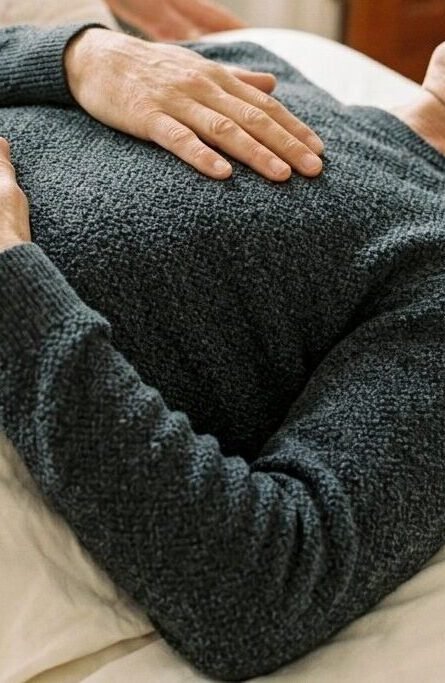 gros plan doux sur le mouvement de la respiration, par exemple une main sur le thorax ou l’abdomen, avec une lumière naturelle